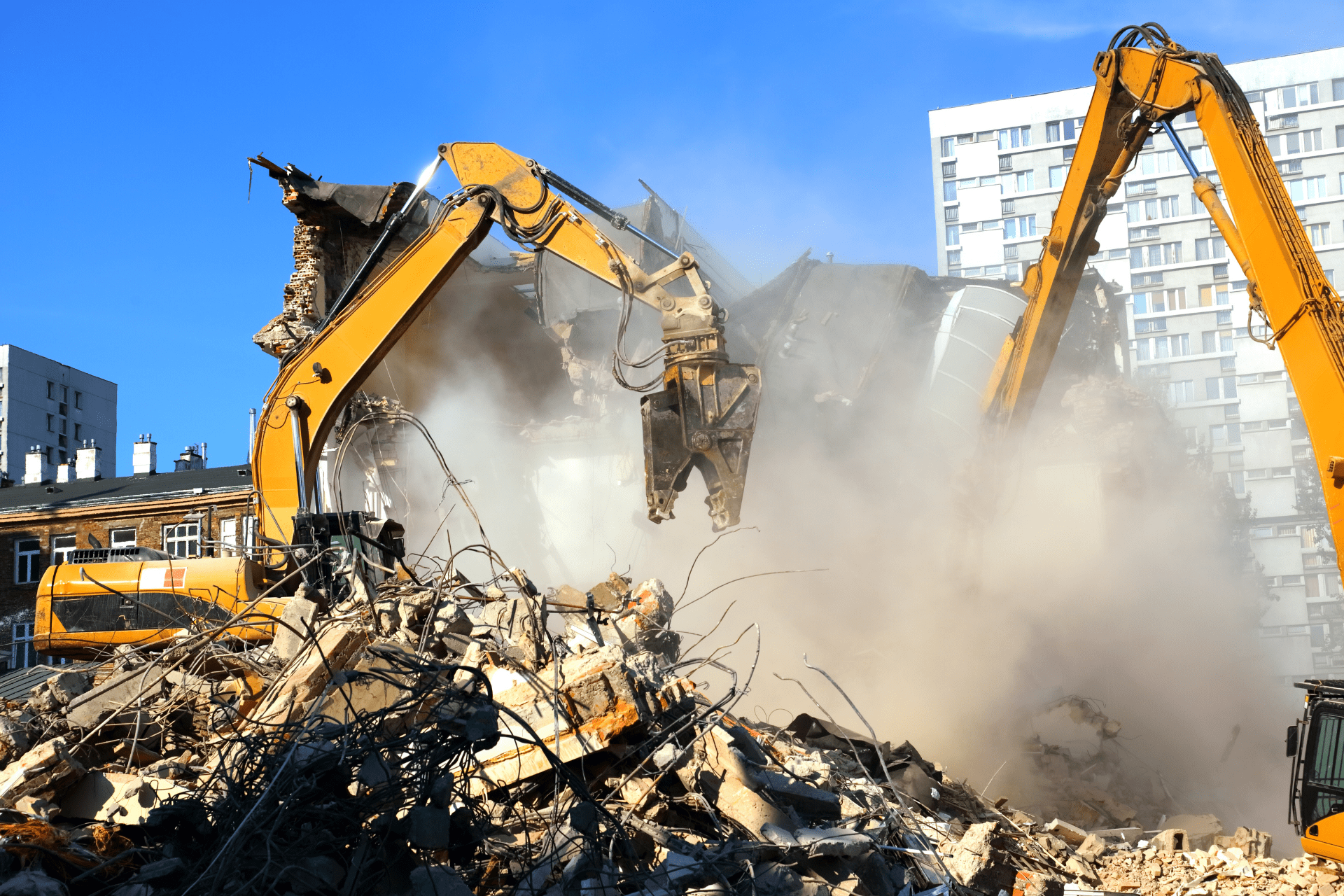 Two excavators demolishing a building during a site clearance