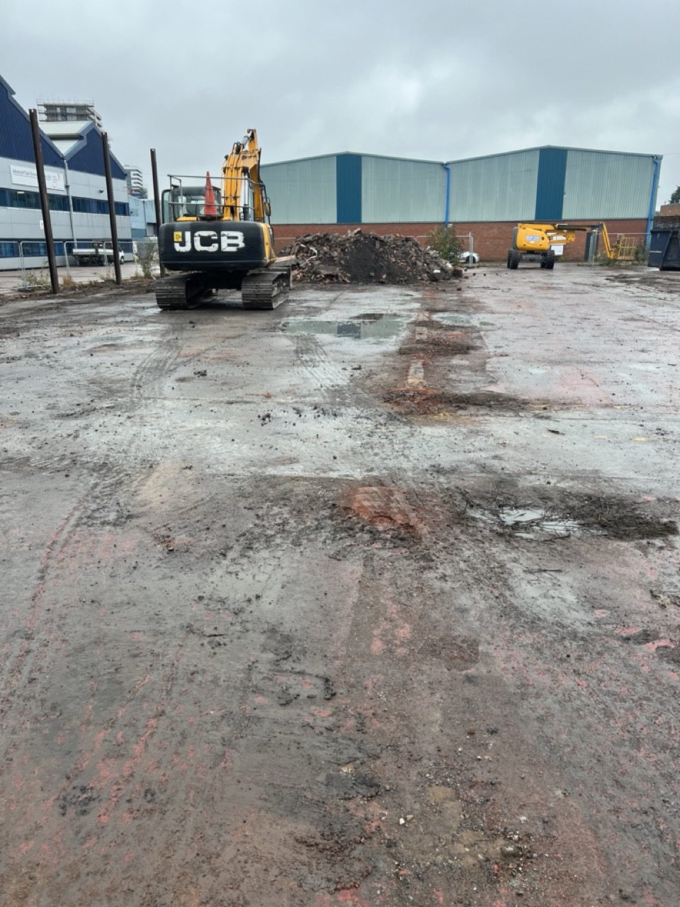 Excavator clearing arisings from the existing concrete yard at a Wolverhampton commercial site