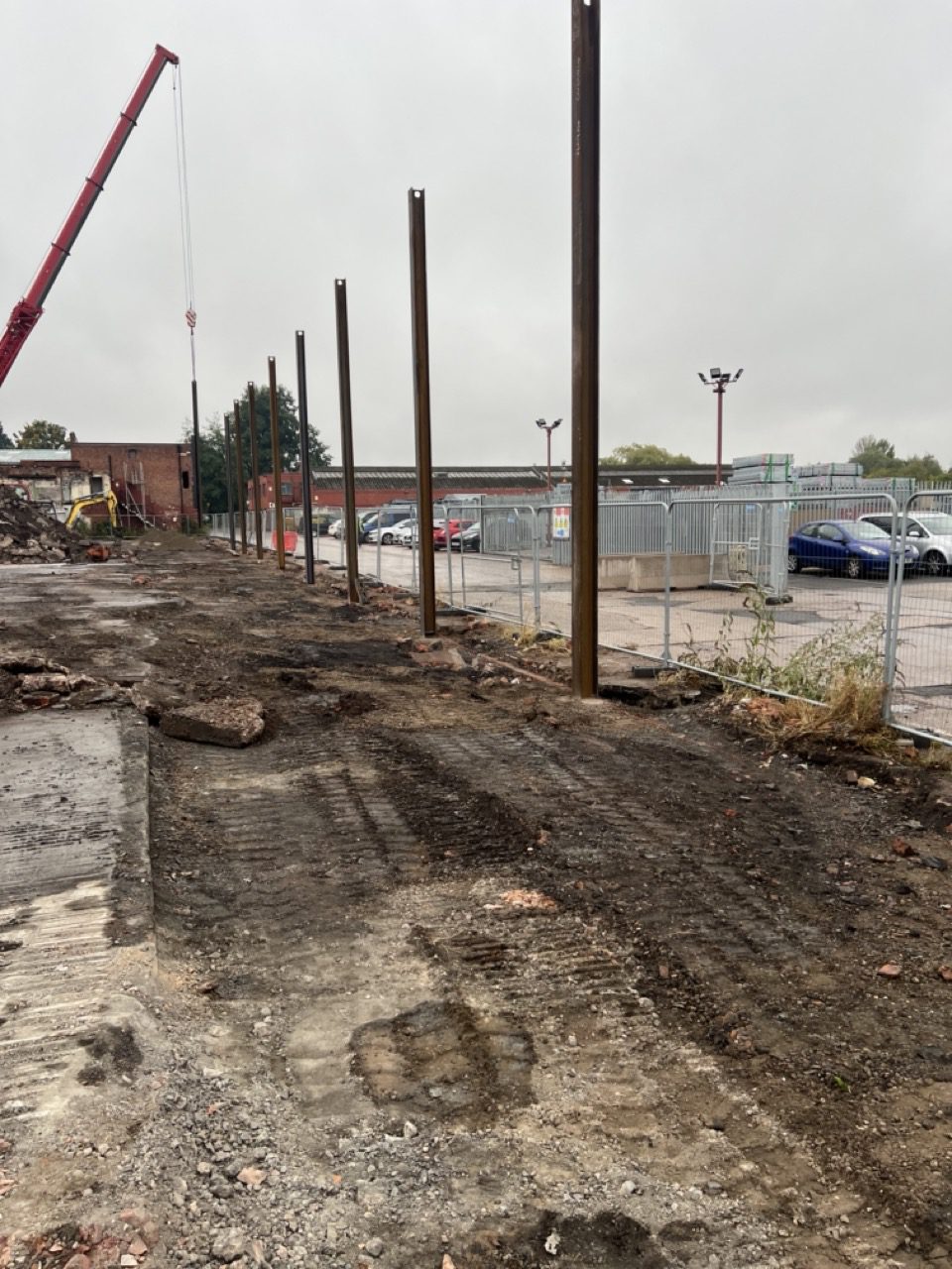 RSJ posts erected with a crane on site, ready for concrete panels on the new perimeter wall