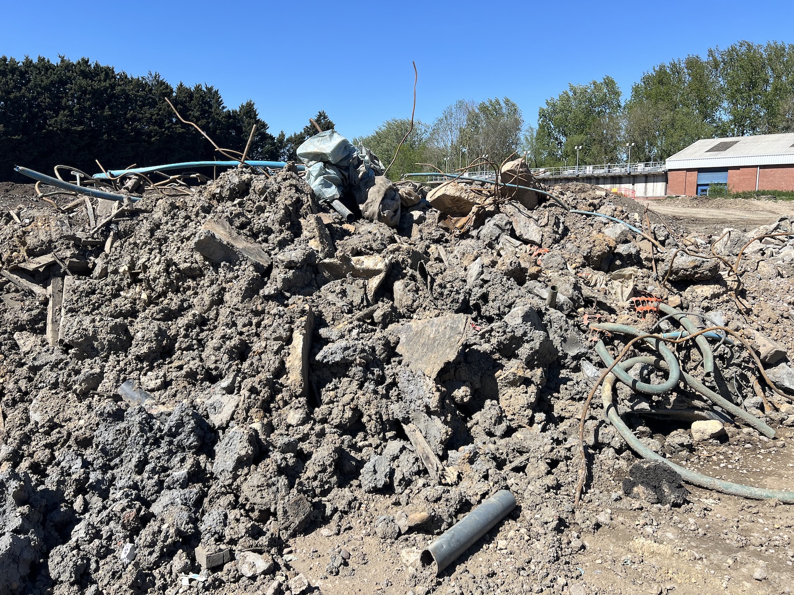 Pile of contaminated mixed hardcore, soil, rebar and old services on a Coventry demolition site