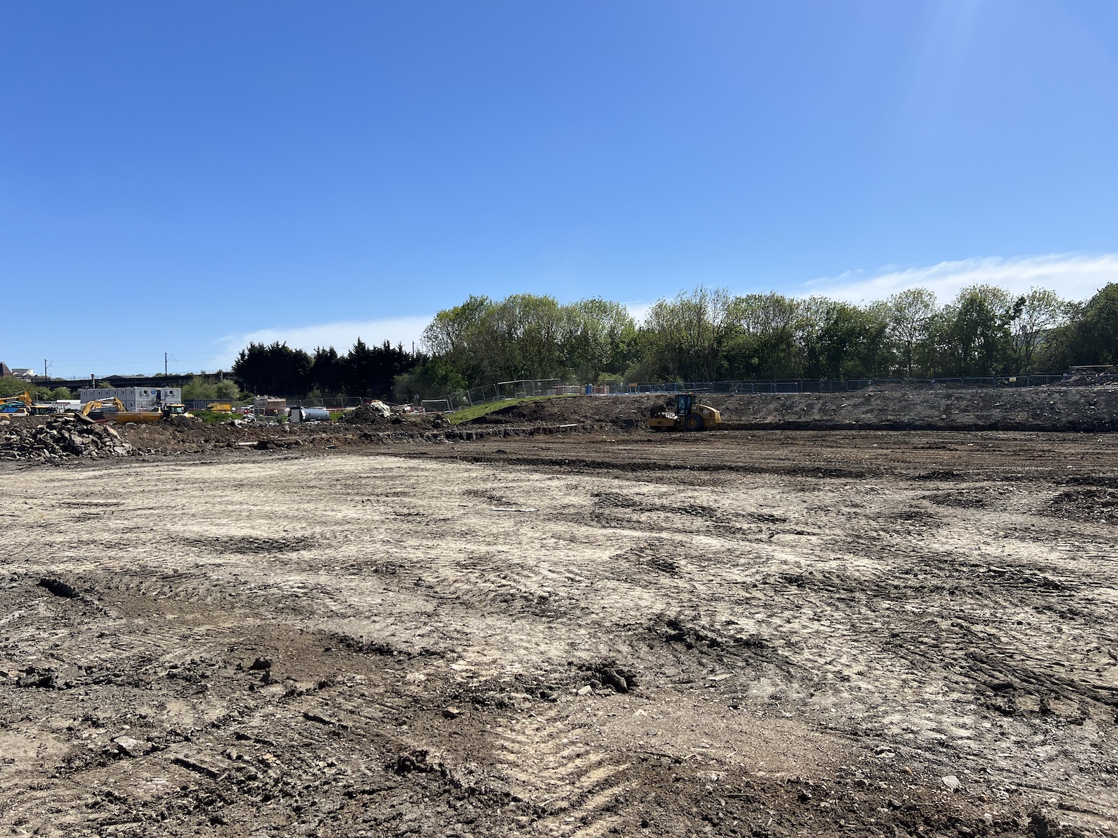 Cleared and levelled demolition site in Coventry with a roller compacting the formation